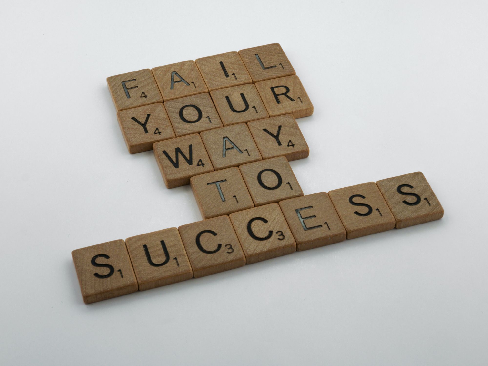 Scrabble pieces reading "Fail your way to success"