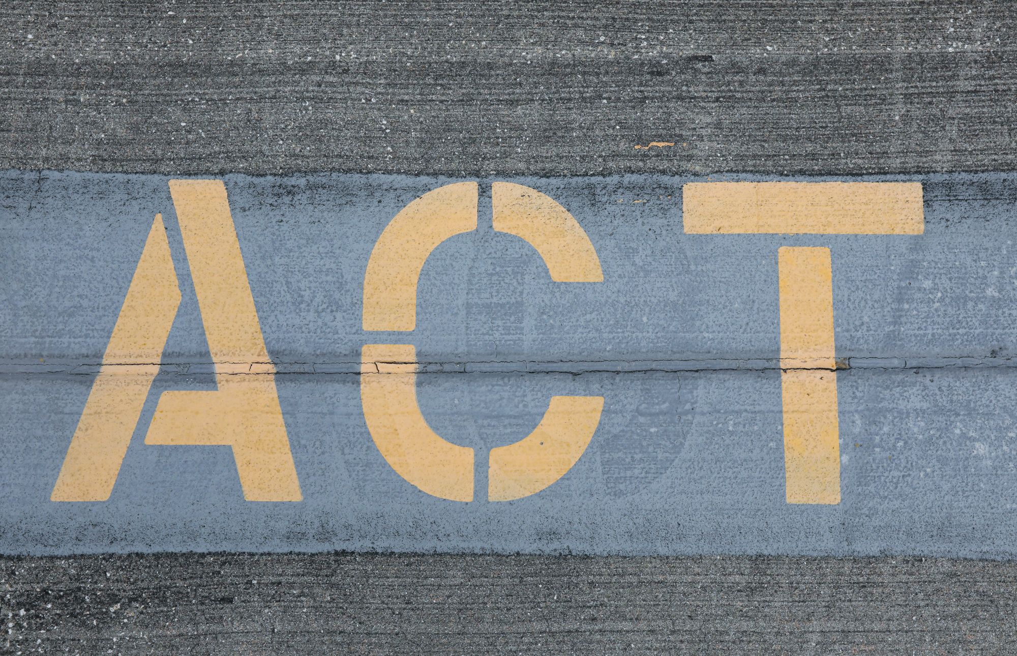 The word ACT stencilled onto a concrete wall