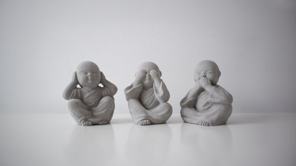 Three Buddha-like toddlers in Hear no Evil, See no Evil, Speak no Evil poses.